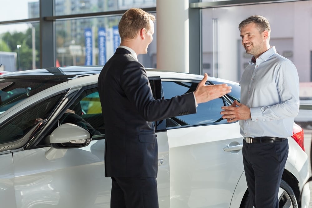 Customer is smiling to his car dealer