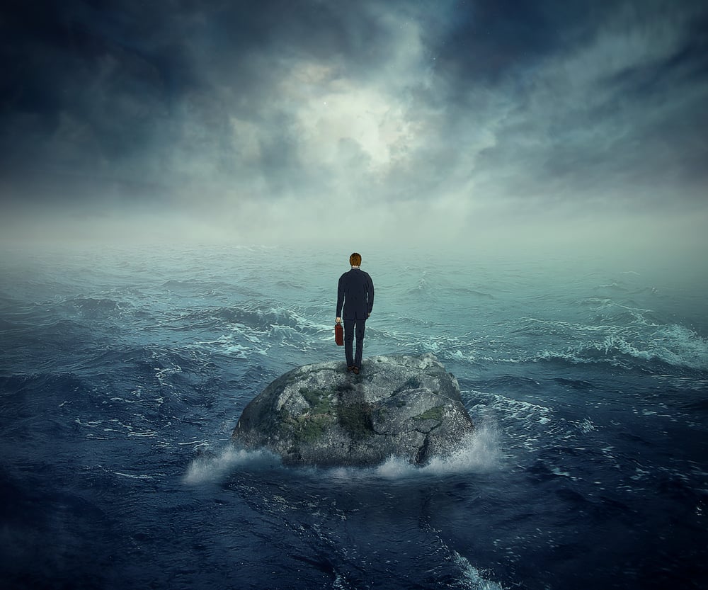 Failure crisis concept and lost business career education opportunity. Lonely young man on a rock cliff island surrounded by an ocean storm waves Failure crisis concept and lost business career education opportunity. Lonely young man on a rock cliff island surrounded by an ocean storm waves