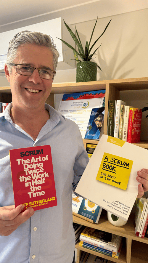 Scrum and A Scrum Book. resources  with Brad holding them