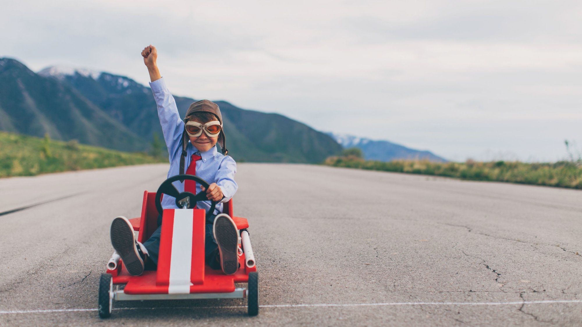Young Business Boy Wins Go Cart race in country with snow mountains